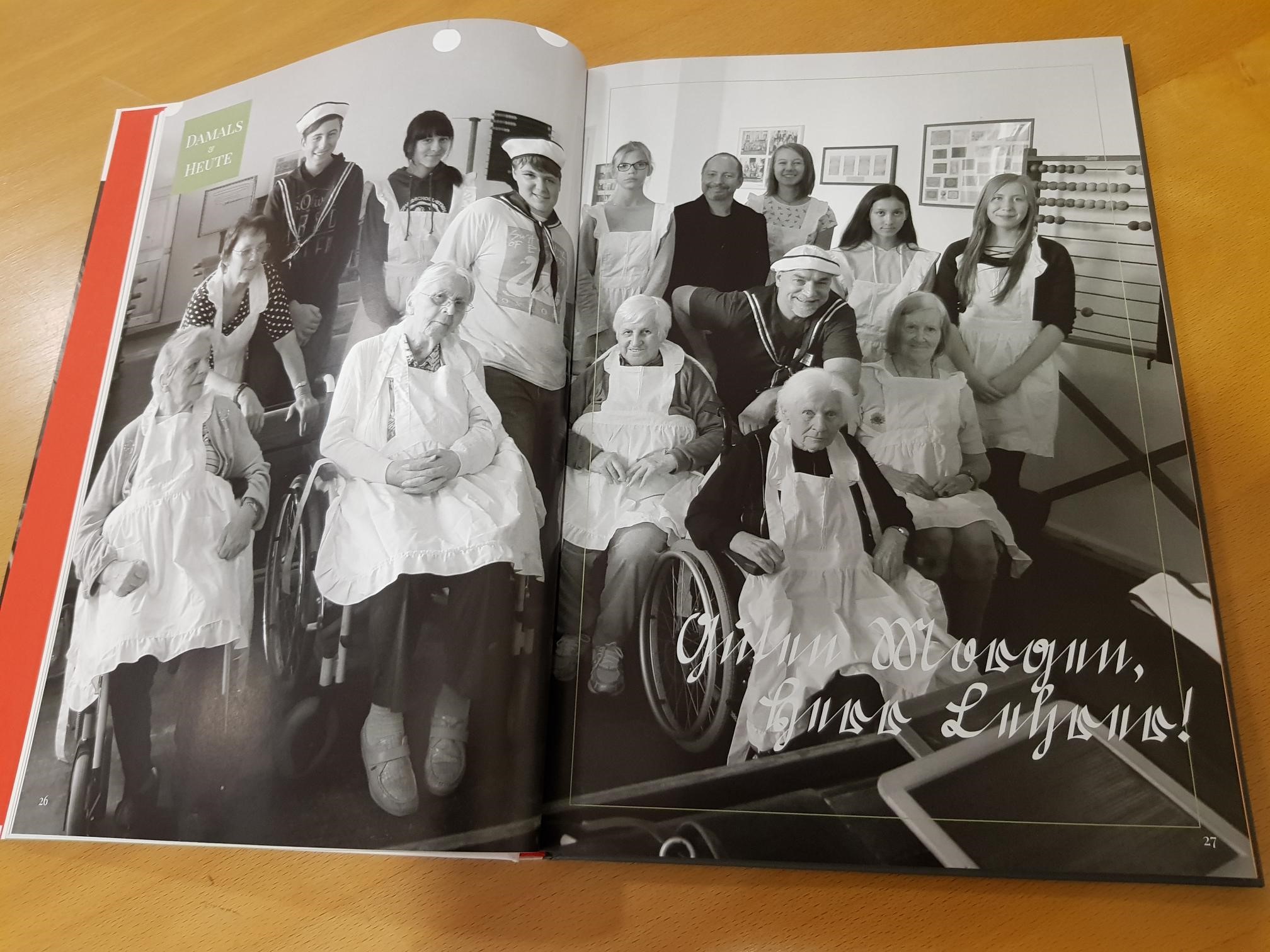 Buch aufgeschlagen Bild in schwarz-weiß zeigt jugne Leute und Rentner.